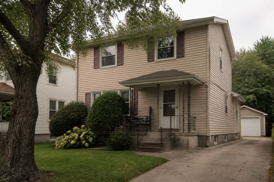 A detached two storey Staten Island house with a driveway running up the side